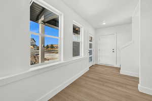 Hall featuring a wealth of natural light and light wood-type flooring