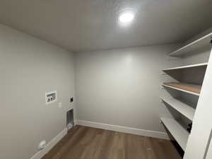 Laundry room with electric dryer hookup, a textured ceiling, washer hookup, and dark hardwood / wood-style floors