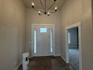 Entrance foyer with a chandelier and dark hardwood / wood-style flooring