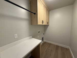 Clothes washing area featuring cabinets, washer hookup, electric dryer hookup, dark hardwood / wood-style flooring, and a textured ceiling