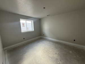 Unfurnished room featuring concrete floors and a textured ceiling