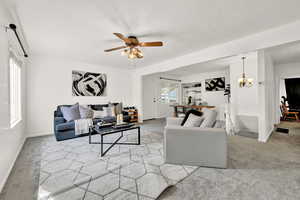 Carpeted living room with ceiling fan