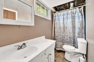 Bathroom with walk in shower, tile patterned flooring, a textured ceiling, toilet, and vanity