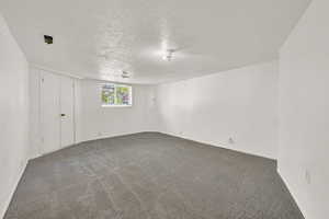 Carpeted empty room featuring a textured ceiling