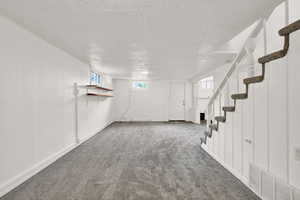 Basement featuring carpet flooring and a textured ceiling