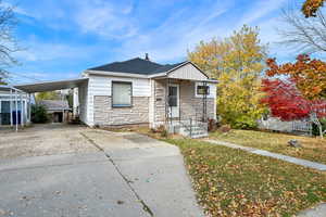 Bungalow-style house featuring a front yard and a carport