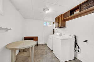 Washroom featuring washing machine and dryer and light hardwood / wood-style flooring