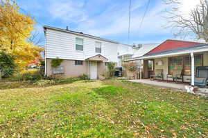 Rear view of house with a lawn and a patio area