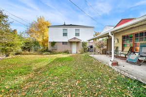 Back of property with a lawn and a wooden deck