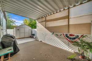 View of patio / terrace featuring a grill and a shed