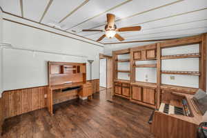 Office area featuring dark hardwood / wood-style floors, ceiling fan, lofted ceiling, and wood walls