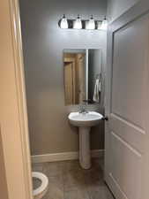 Bathroom featuring tile patterned floors, sink, and toilet