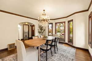 Dining room with dark hardwood / wood-style flooring and crown molding