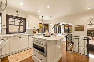 Kitchen with sink, dark wood-type flooring, a kitchen island, white cabinets, and appliances with stainless steel finishes