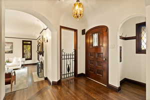 Foyer featuring a notable chandelier and dark wood-type flooring