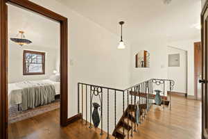 Stairway with hardwood / wood-style floors and electric panel