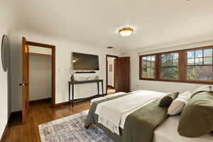 Bedroom with dark hardwood / wood-style flooring