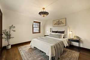 Bedroom with dark hardwood / wood-style floors and lofted ceiling