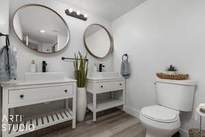 Bathroom with hardwood / wood-style floors, vanity, and toilet