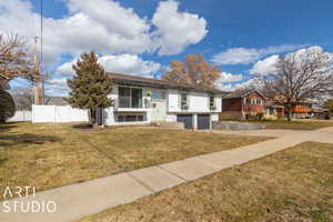 Raised ranch featuring a front yard and a garage