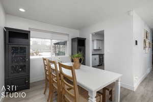 Dining space featuring a textured ceiling and light wood-type flooring