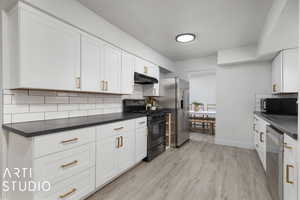 Kitchen with backsplash, light hardwood / wood-style flooring, white cabinets, and black appliances