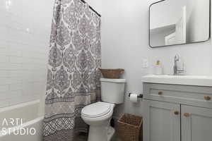 Full bathroom with vanity, toilet, and shower / bathtub combination with curtain