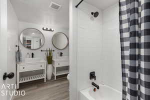 Full bathroom featuring shower / bath combo with shower curtain, vanity, wood-type flooring, and toilet