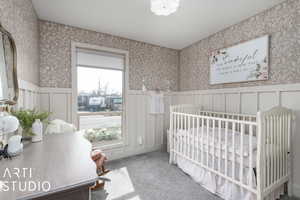 Bedroom with carpet flooring and a nursery area