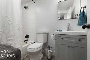 Full bathroom with vanity, shower / bathtub combination with curtain, wood-type flooring, and toilet