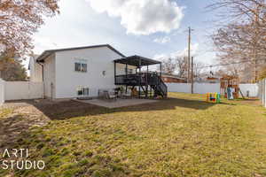 Rear view of property with a playground, a yard, and a patio