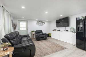 Walk out basement.  Living room with a textured ceiling and light hardwood / wood-style flooring