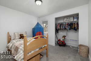 Carpeted bedroom featuring a textured ceiling and a closet