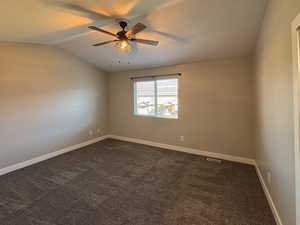 Primary suite with ceiling fan and lofted ceiling