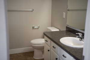 Bathroom featuring linoleum patterned flooring, vanity, and toilet