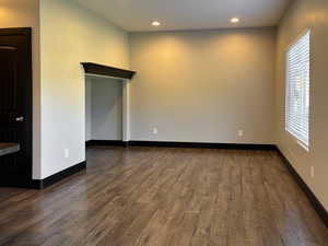 Spare room featuring dark LVP / wood-style flooring