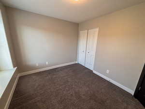 Bedroom featuring dark colored carpet and a closet