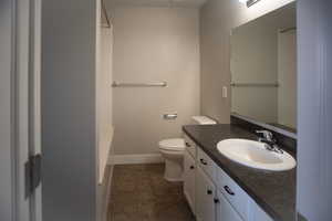 Bathroom featuring linoleum patterned flooring, vanity, and toilet