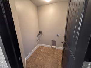 Laundry area with hookup for an electric dryer, tile patterned linoleum floors, and hookup for a washing machine