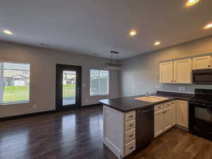 Kitchen with kitchen peninsula, appliances with stainless dishwasher, white cabinets, and sink