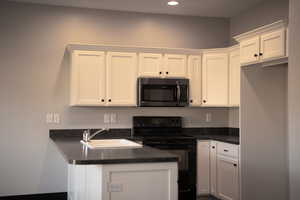 Kitchen featuring white cabinetry with crown molding, sink, and black / electric stove