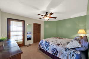 Bedroom featuring light colored carpet and ceiling fan