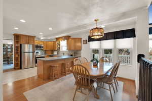 Dining room featuring a chandelier, light hardwood / wood-style floors, a healthy amount of sunlight, and sink