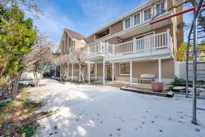 Rear view of property featuring a balcony and a patio