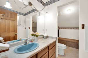 Bathroom featuring tile patterned floors, vanity, toilet, and a tub/shower.