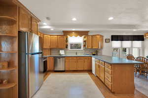 Kitchen with sink, appliances with stainless steel finishes, tasteful backsplash, light hardwood / wood-style floors, and kitchen peninsula