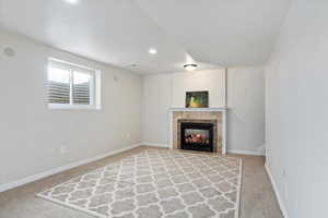 Unfurnished living room with carpet floors and a tile fireplace