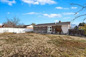 Rear view of property with a yard