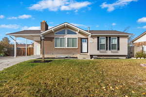 View of front of property with a front lawn and a carport