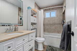 Full bathroom featuring vanity, toilet, shower / bathtub combination with curtain, and hardwood / wood-style flooring